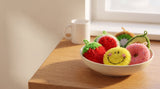 A bowl of all six frubbies on a wooden kitchen counter