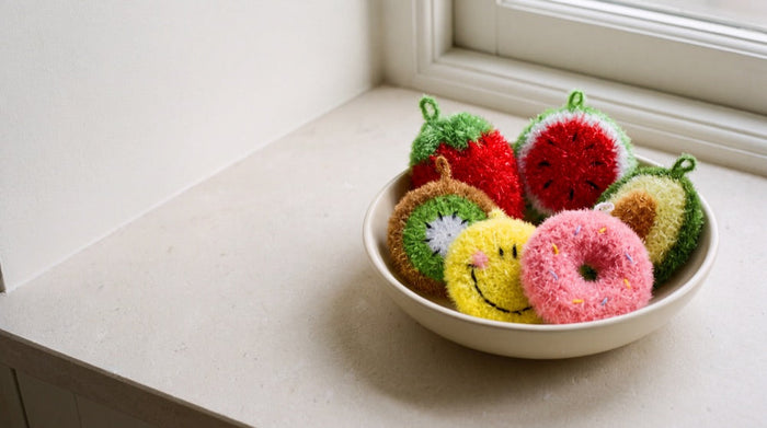 All six frubbies scrubbers in a bowl on a bright windowsill